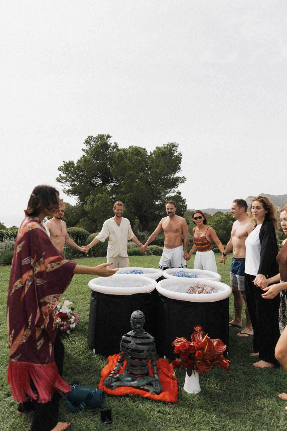 Group holding hands around four cold plunges at Experiment Retreat Ibiza 2024